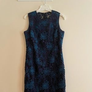 Embroidered lace, sheer neckline, back kick pleat, fully lined.